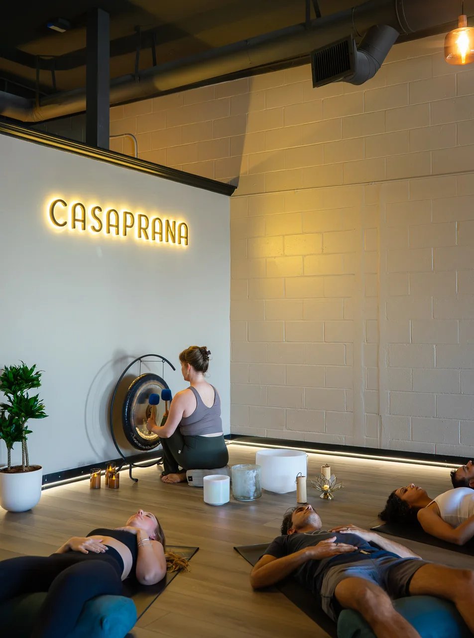 A gong and crystal bowls beside students resting on their mats